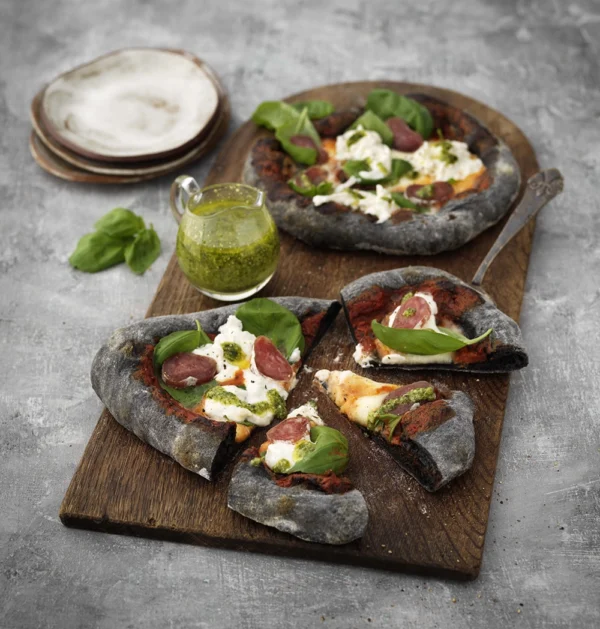 Svart pizza med fuet, burrata och pesto