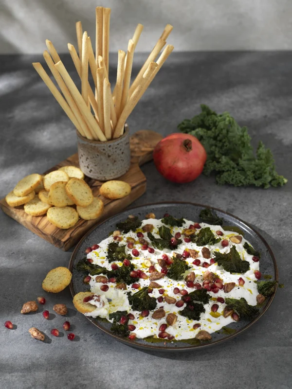 Stracciatella med grönkålschips, granatäpple och kanderade mandlar